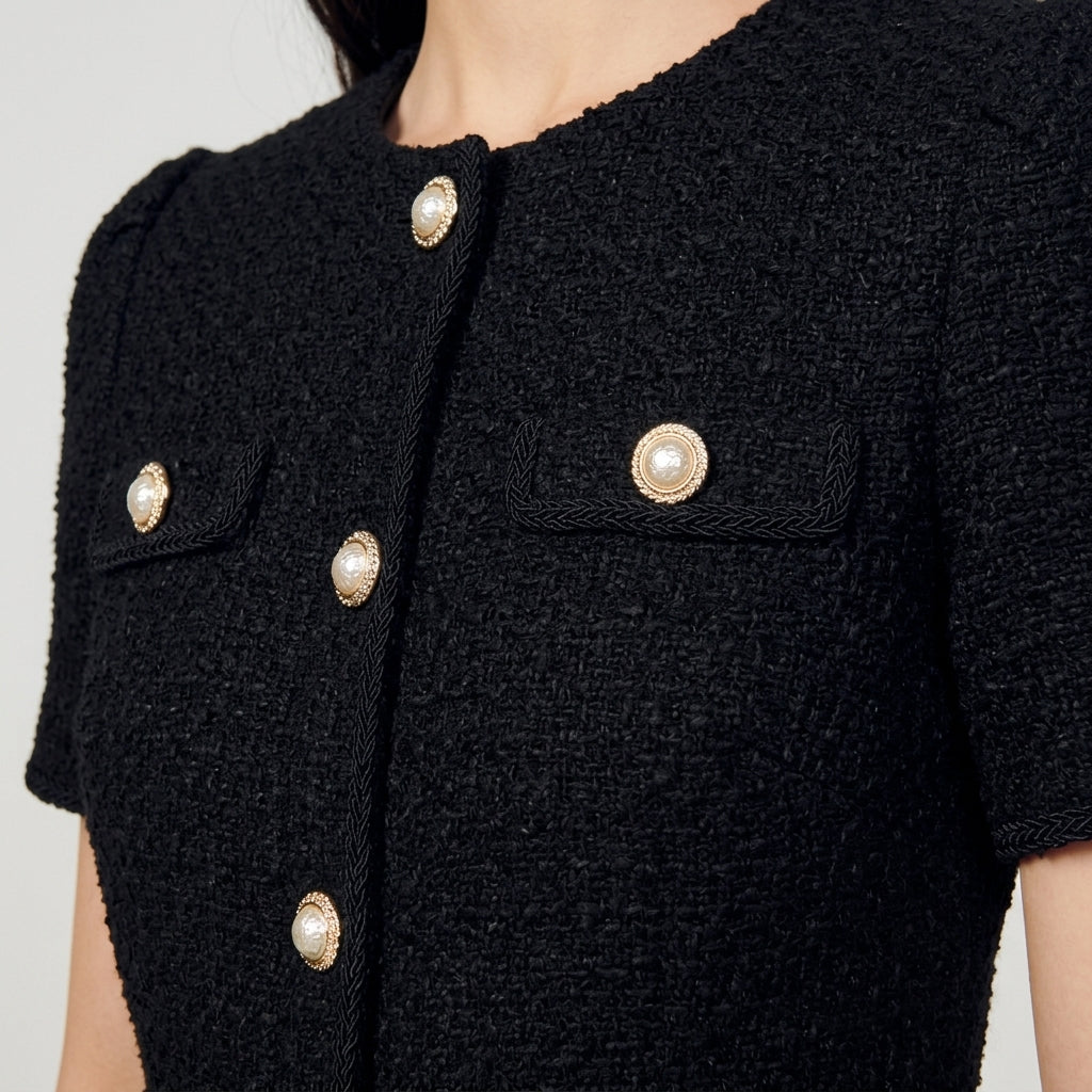 Textured tweed fabric and gold button detail close-up